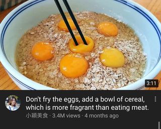 Chopsticks pierce egg yolks on a bed of raw oats in a still for a video entitled ‘Don't fry the eggs, add a bowl of cereal, which is more fragrant than eating meat’.