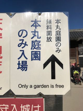 A sign reads “Only a garden is free” on the grounds of Matsumoto Castle, Japan.